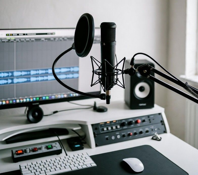 A tidy home recording setup with a microphone on a desk